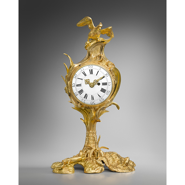 Une petite pendule au palmier surmontée d’un aigle, coquillage escargot et lézard