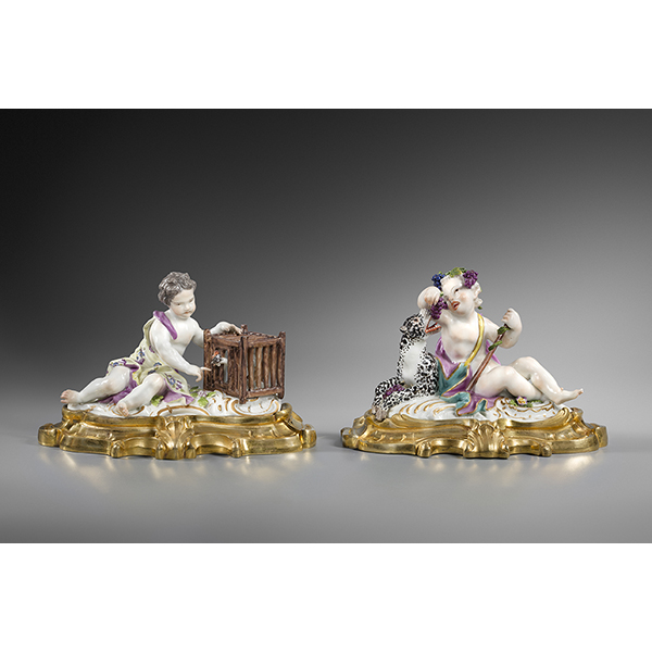 Une paire de presse-papiers en porcelaine de Meissen représentant deux enfants assis